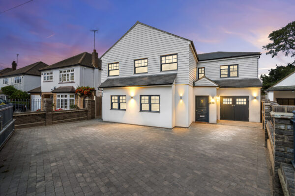 Property exterior at dusk with warm lighting and dramatic sky